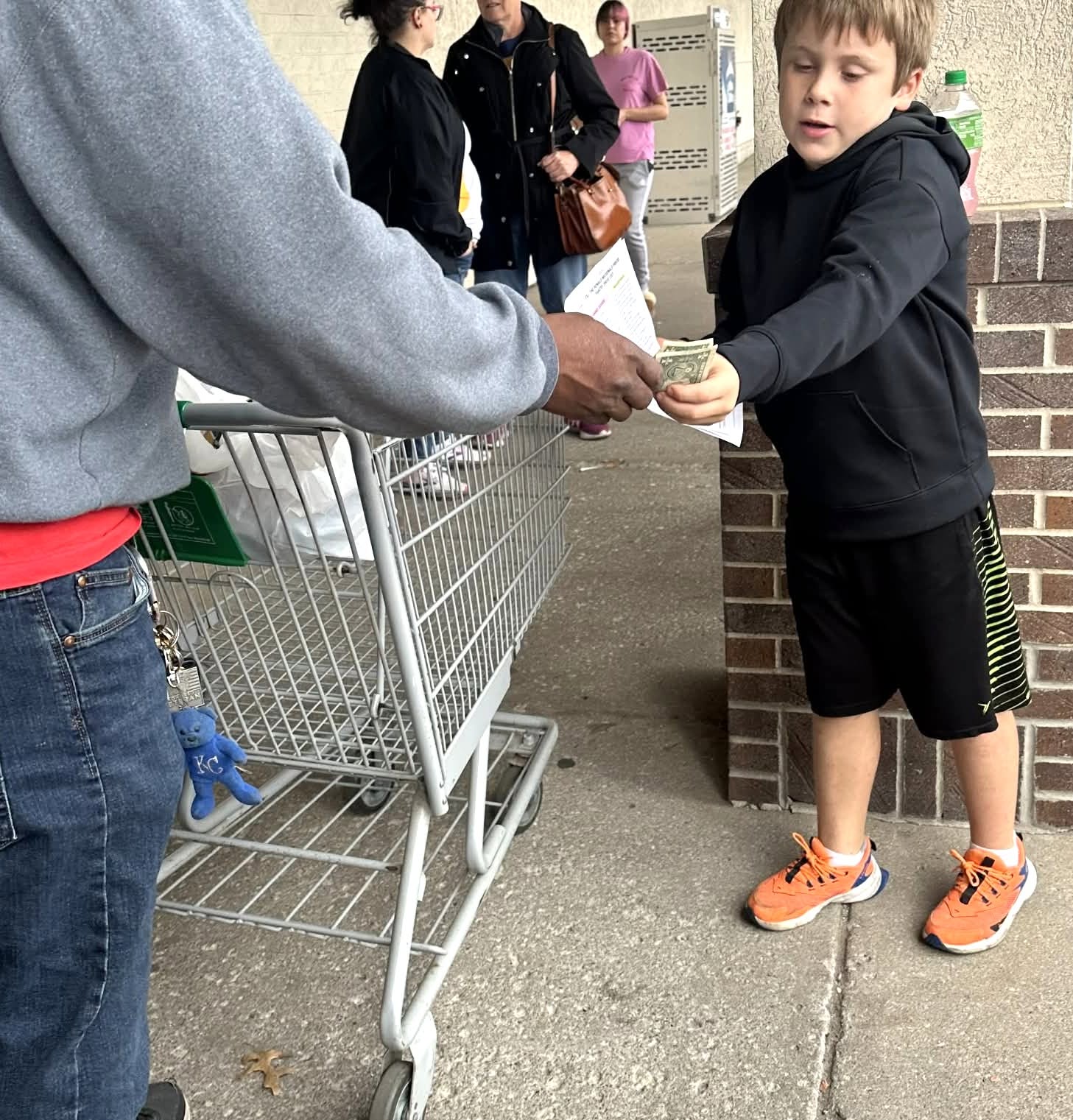 Child collecting money at the fill the pantry event.